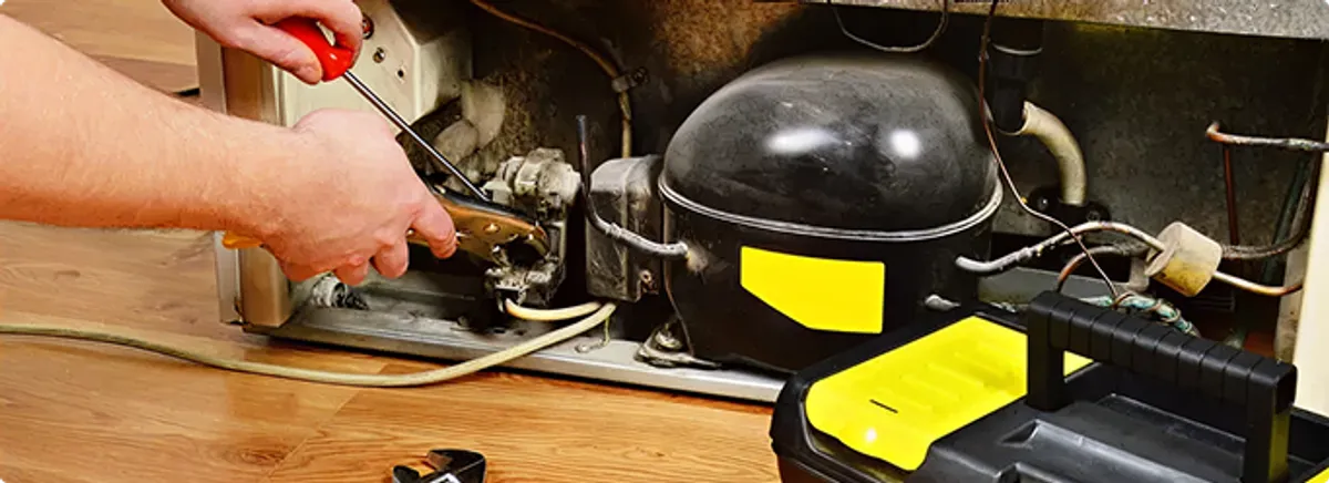 Refrigerator repair technician fixing the compressor and wiring in Loris, SC