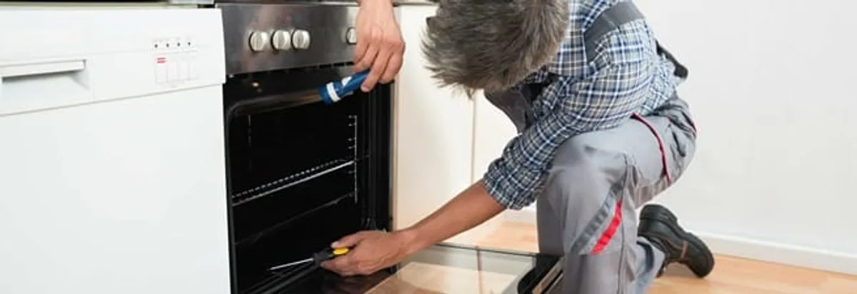 Oven repair technician inspecting and servicing an electric oven in Myrtle Beach, SC